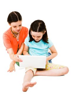 Two girls using a laptop isolated over white