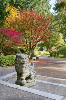 Shishi Lion Protector Stone Statue in Japanese Garden in Fall