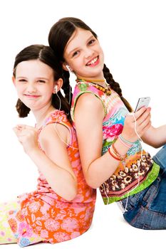 Portrait of girls listening to MP3 player and smiling isolated over white