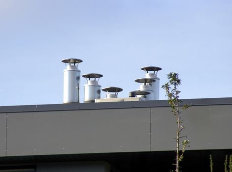 Pipes of ventilation on a background of the blue sky