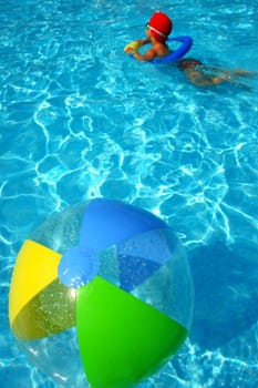 A colorful beach ball floating on the swimming pool.