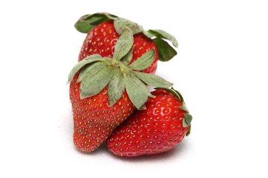 a trio of strawberries on a white background