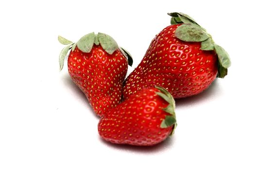 A trio of strawberries on a white background