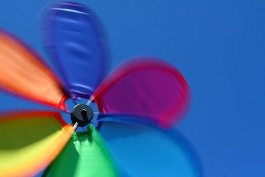 A spinning colorful pinwheel set against a blue sky