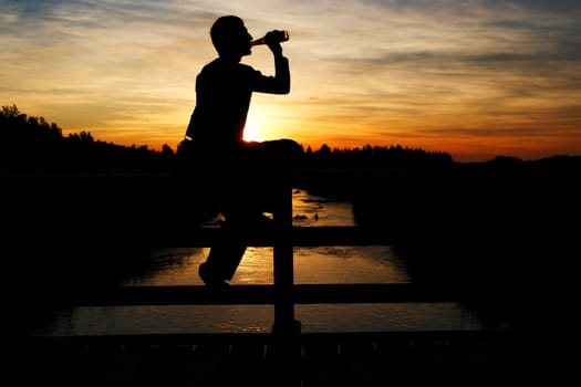 A person sitting on a bridge and listening to the music