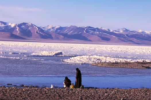 Landscape of snow-capped mountains and frozen lake in winter