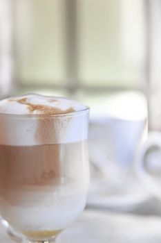 A glass with  cappuccino and whipped cream