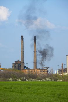 Old industrial plant with smoke rising