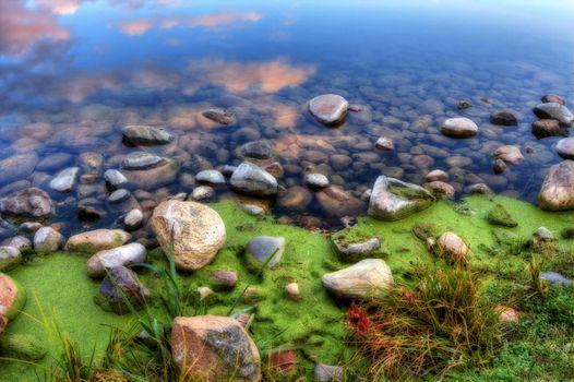HDR of a rocky bank on a river.