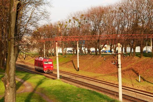 Single electric locomotive is moving on a railroad track in urban areas. Khmelnytsky, Ukraine