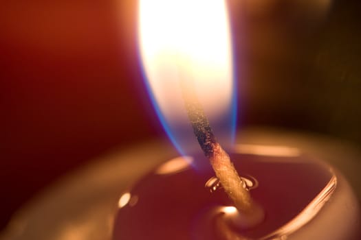 A close up of a lit candle and wick.