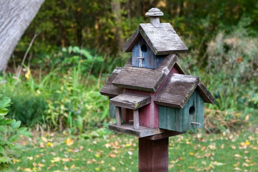 Home made wooden bird house on a pole.