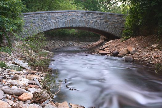 Silky river water running under a bridge.