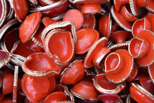 A background of traditional lamps in red color used in Diwali festival rituals, in India.