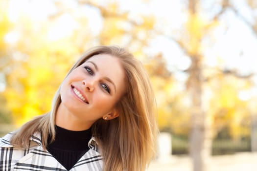Pretty Young Woman Smiling in the Park on a Fall Day.