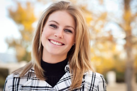 Pretty Young Woman Smiling in the Park on a Fall Day.