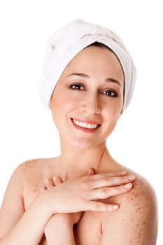 Beautiful happy healthy radiant woman female face with towel around head finished bath shower spa treatment touching her shoulder skin with freckles, isolated.