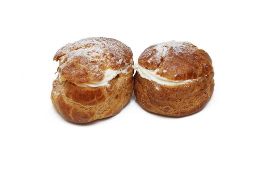 Two pastries filled with custard over white background