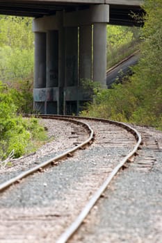 Train Tracks leading up to an overpass.