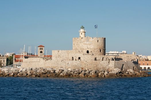 Medieval fortress of Saint Nicholas, now the site of a lighthouse, in Mandraki Harbour, Rhodes New Town, Greece.