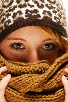 young redhead woman with winter fashion hiding behind scarf