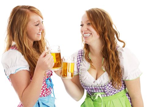 tow bavarian girls with beer skoaling at each other on white background