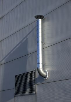 Pipe of ventilation are located on a wall of a building