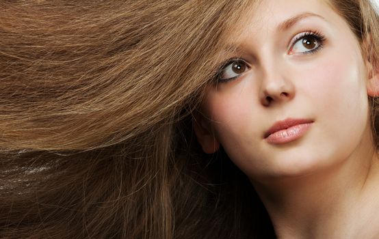 Healthy beautiful long hair closeup in motion created by wind. Portrait