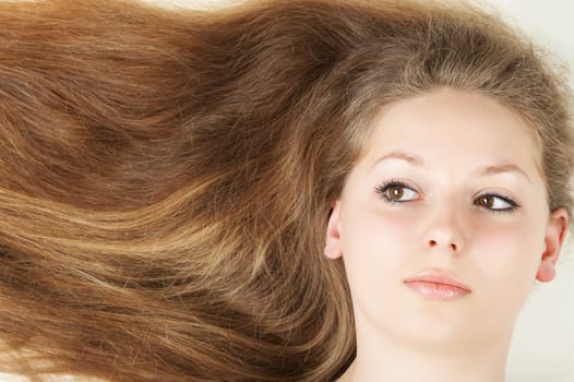 Healthy beautiful long hair closeup in motion created by wind. Isolated on white