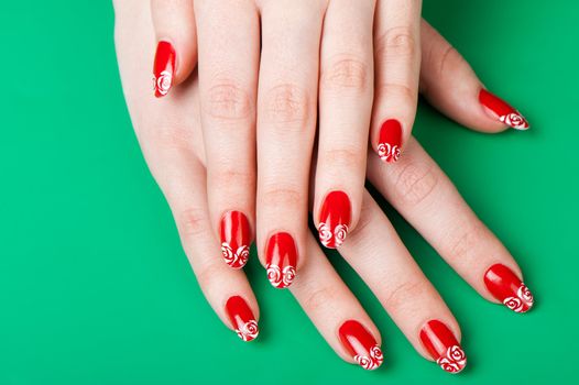 Female hands with French manicure. It is isolated on a green background