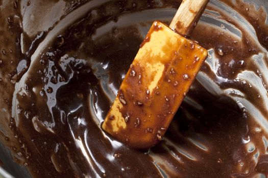 Bowl with remains of chocolate batter and spatula.