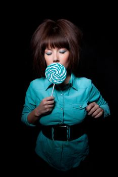 young woman with lolipop, black background