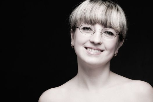 Portrait of the woman in eyeglasses close up. The bared shoulders. Toned image.