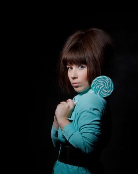 young woman with lolipop, black background