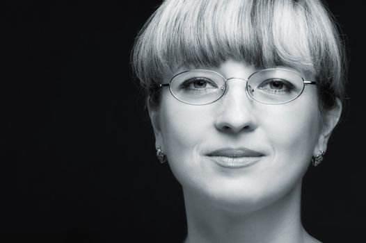 Portrait of the woman in eyeglasses close up. The bared shoulders. Toned image.