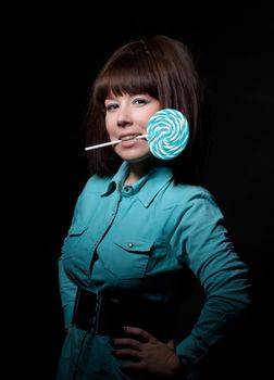 young woman with lolipop, black background