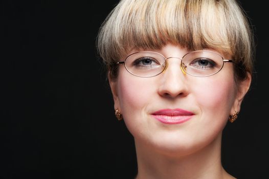 Portrait of the woman in eyeglasses close up. The bared shoulders.