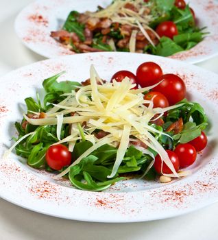 Arugula with tomatoes cheese bacon and pine nuts