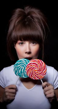 young woman with lolipop, black background