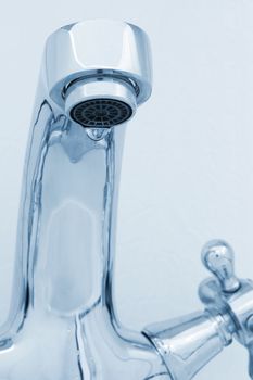 tap with drop water. Cold toned image. Closeup