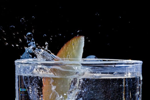 The motion of a slice of apple splashing into a glass of water