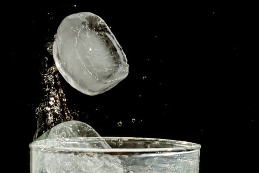 The motion of ice splashing into a glass of water frozen in time