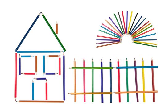 The house, fence and the sun from color pencils. It is isolated on a white background. Abstract concept
