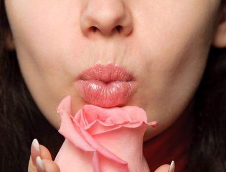 The woman with a rose. A photo close up parts of the person and a flower