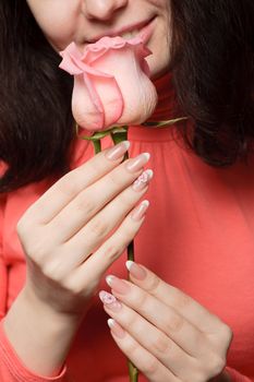 The woman with a rose. A photo close up parts of the person and a flower