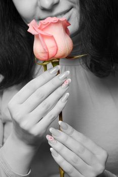 The woman with a rose close up. The monochrome image of the woman and a color rose