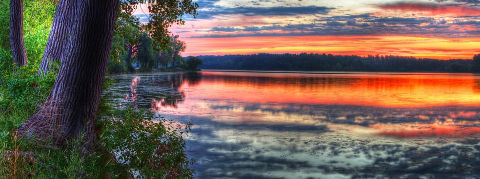 Panorama of a beautiful sunrise on a lake.