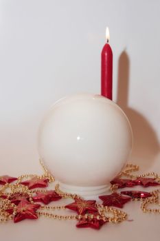 christmas crystal ball against a bright background with candles
