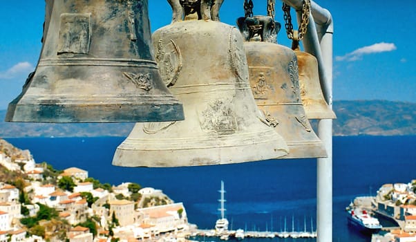 Four big bells close up against blue sea 