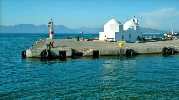 Small white greek church on the pier